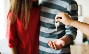 A couple being handed their keys to a new home