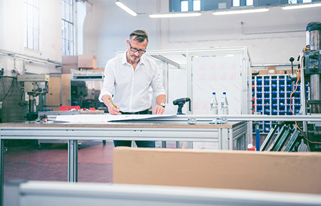 A man sketching in a bright workshop