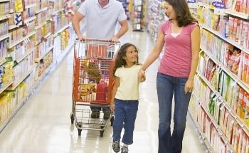 A mother leads her daughter down a grocery store aisle